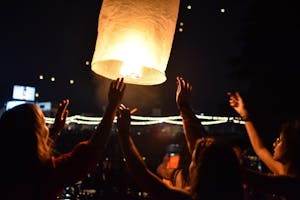 Personas lanzando una linterna al cielo por la noche en Chiang Mai durante el festival de las linternas en Tailandia.