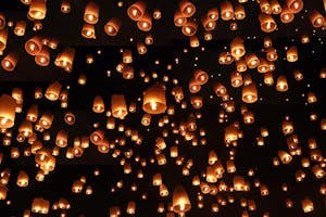 Cientos de linternas iluminadas flotando en el cielo nocturno durante el festival de las linternas en Tailandia.