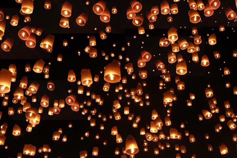 Cientos de linternas iluminadas flotando en el cielo nocturno durante el festival de las linternas en Tailandia.